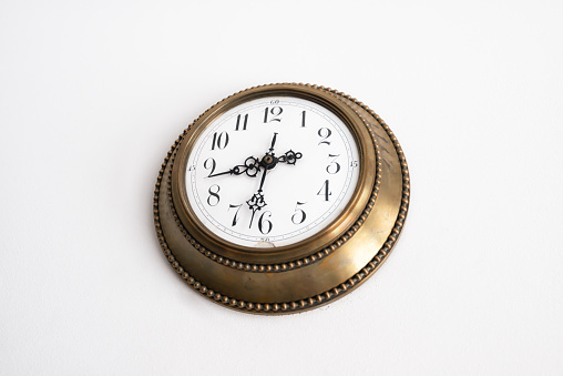 A vintage clock hanging on white wall