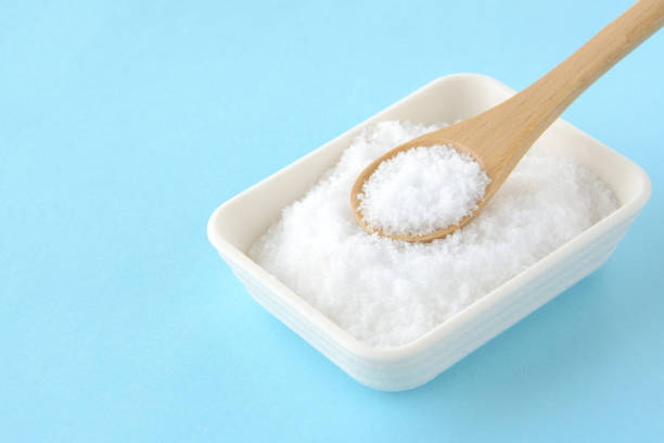 istock Dish of salt and spoon on light blue background 1327756645
