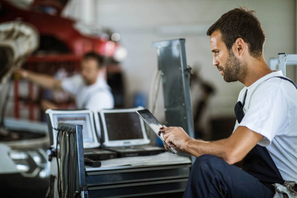 istock Mechanic using touchpad in auto repair shop. 1327756769