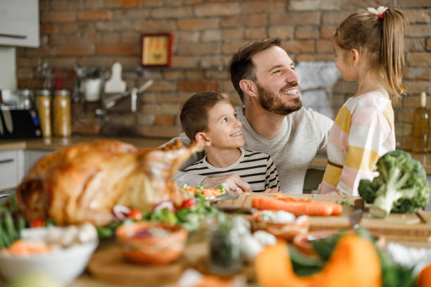 istock Happy single father and his kids talking on Thanksgiving day. 1327758030