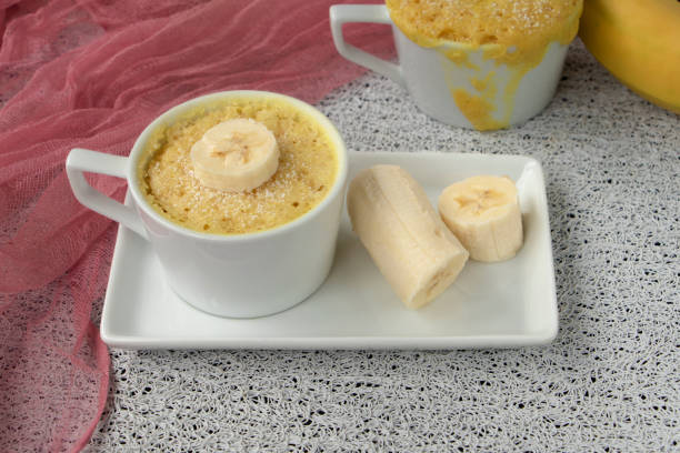 istock cupcake in a mug with banana pieces. Banana cupcake on a light background. 1327759970