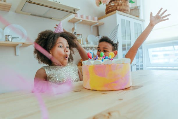 キャンドルで誕生日ケーキを見て幸せな女の子 - cake birthday domestic kitchen child ストックフォトと画像