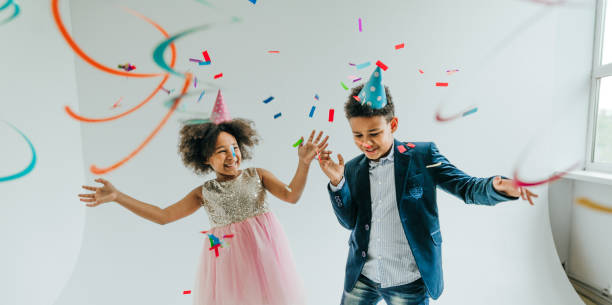 istock Happy girl and boy in party hat dancing on white background 1327763523