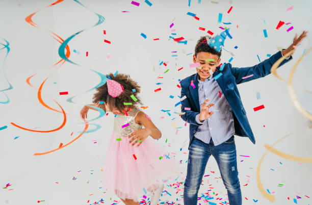 istock Happy girl and boy in party hat dancing on white background 1327763539
