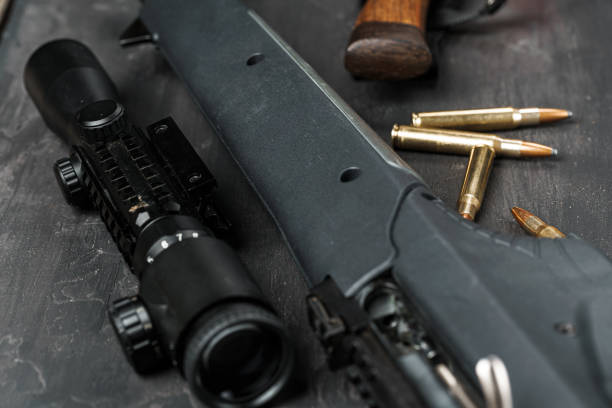 istock The optical sight and shotgun on wooden backgorund 1327763614