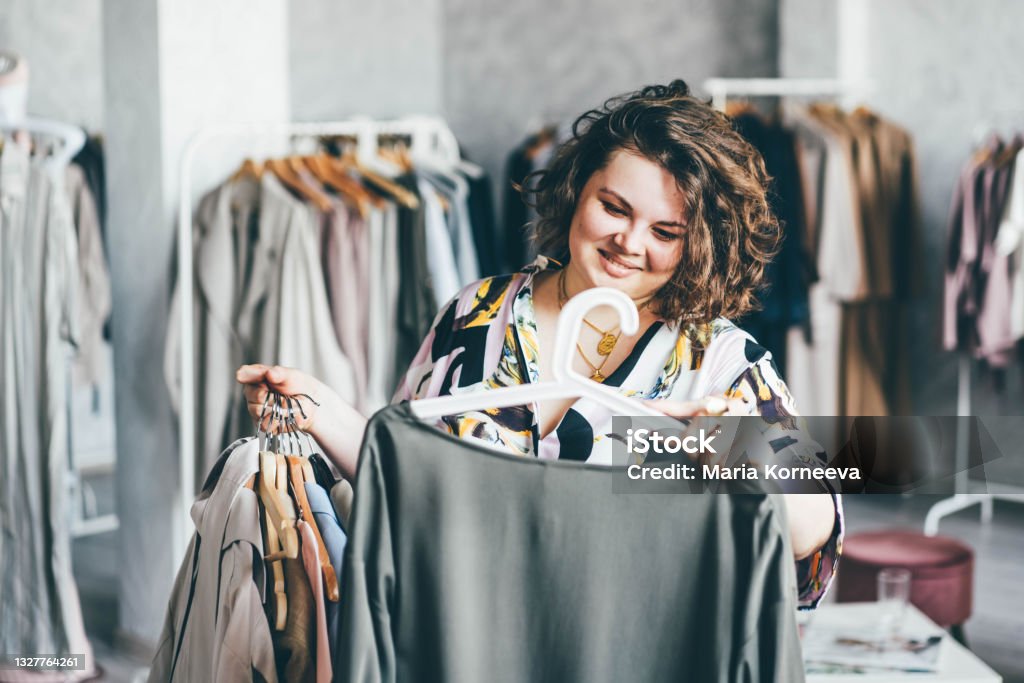 Plus Size Woman Choose Fashioned Dress in Store. Plus size women shopping. Retail Stock Photo
