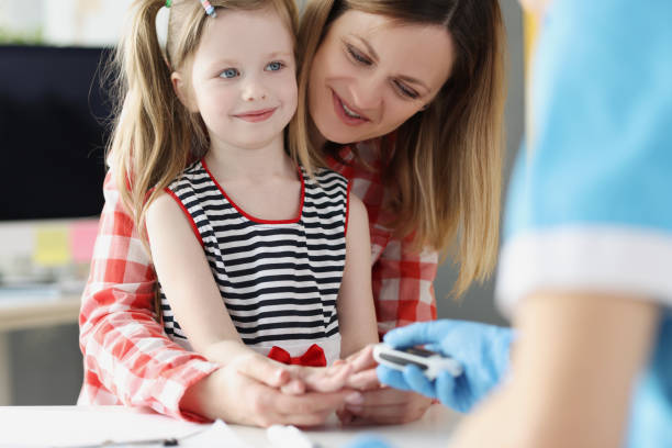 el médico controla el nivel de azúcar en la sangre de una niña pequeña usando glucómetro digital en el hospital - diabetes blood illness chronic fotografías e imágenes de stock