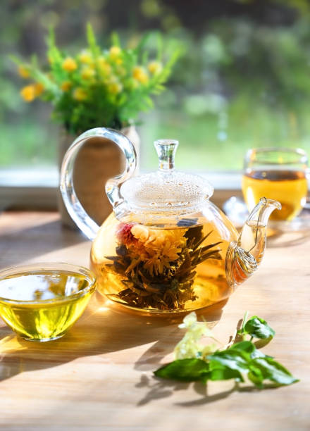 istock Glass tea pot with a blooming tea flower 1327764776