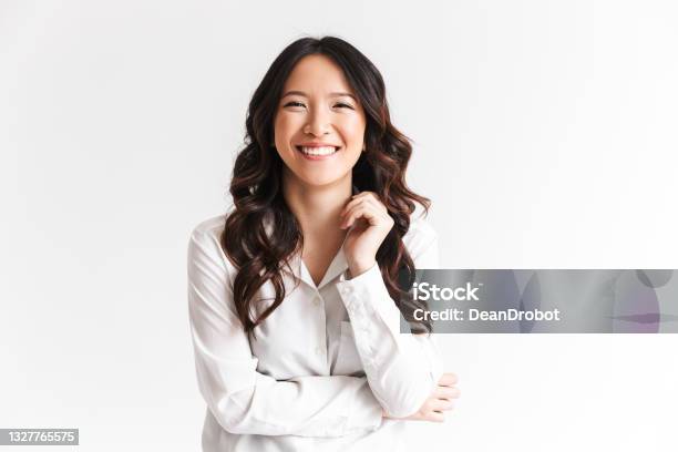 Portrait Of Gorgeous Asian Woman With Long Dark Hair Laughing At Camera With Beautiful Smile Isolated Over White Background In Studio Stock Photo - Download Image Now