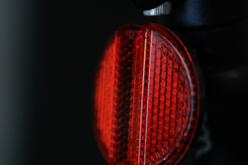 Shallow depth of field (selective focus) details of a bicycle single retro-reflector.