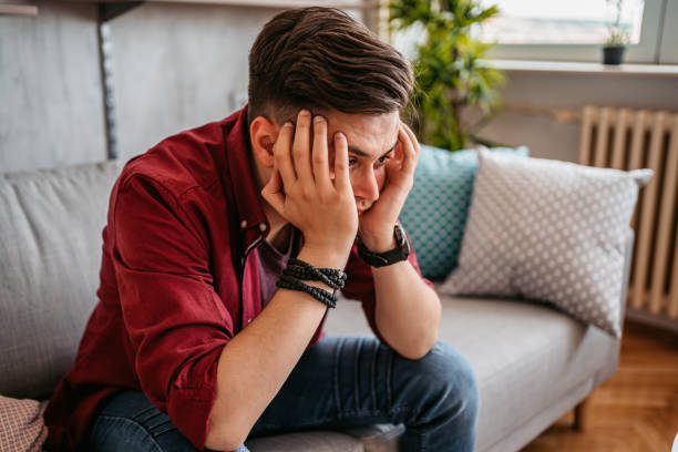 istock Man sitting alone at home looking sad and distraught 1327766810