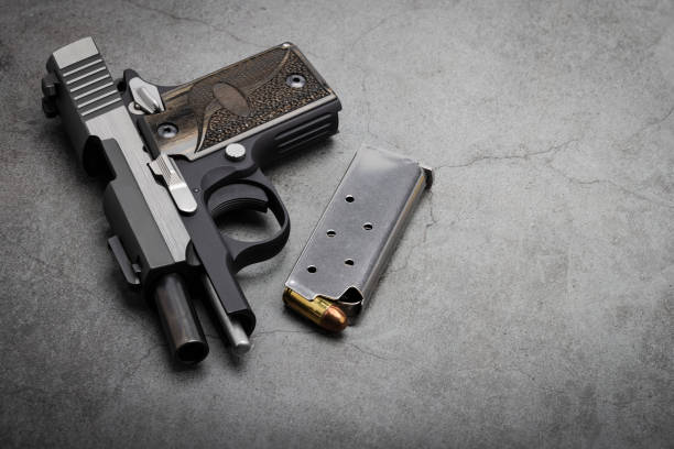 istock Semi automatic pistol hand gun with bullet magazine on texture background , Back up gun 1327766943