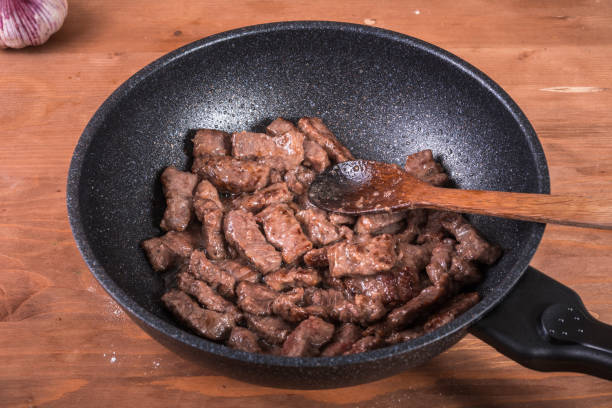 istock Cooking beef stroganoff - fried pieces of beef in a pan, the first step in making beef stroganoff 1327767125