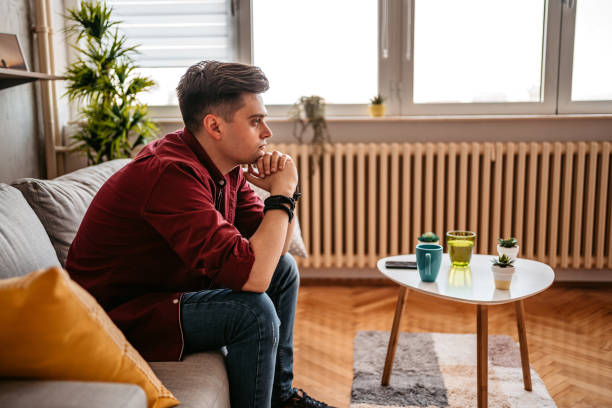 istock Man sitting alone at home looking sad and distraught 1327767288