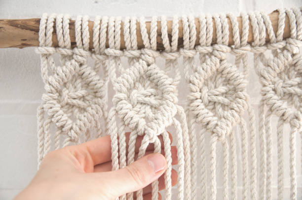 istock Boho wall mural made of natural color cotton threads using macrame technique for home and wedding decor in the production process 1327767954