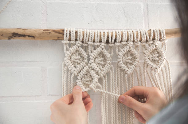 istock Boho wall mural made of natural color cotton threads using macrame technique for home and wedding decor in the production process 1327767967