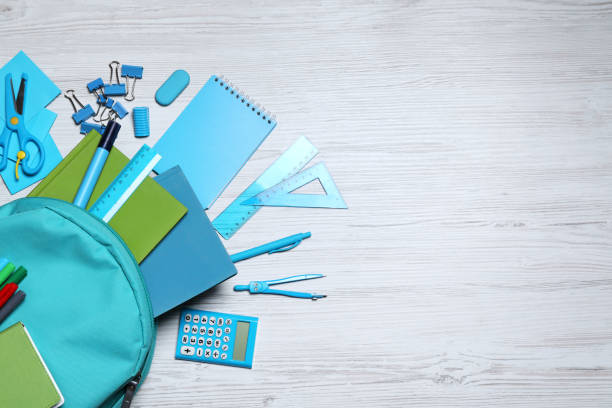 istock Flat lay composition with backpack and school stationery on white wooden background, space for text 1327768029
