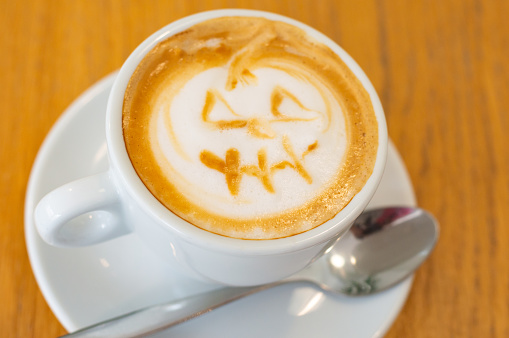 Tasty cup of coffee with a drawing on the milk foam in the shape of a pumpkin