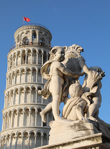 Pisa, PI, Italy - August 21, 2019: Tower of Pisa and Statues of Cherubs