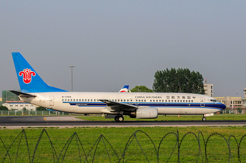 June 28, 2009- Beijing, China: Beijing Capital International Airport (BCIA) is the largest airport in Asia and the second largest airport in the world (airport passenger throughput over 100 million in 2019, second to Atlanta Airport, USA). It has three runways and photographers can find ideal place to shot airplane images.   Here is a Boeing 737 airplane of China Southern Airlines leaving the west runway  of BCIA.