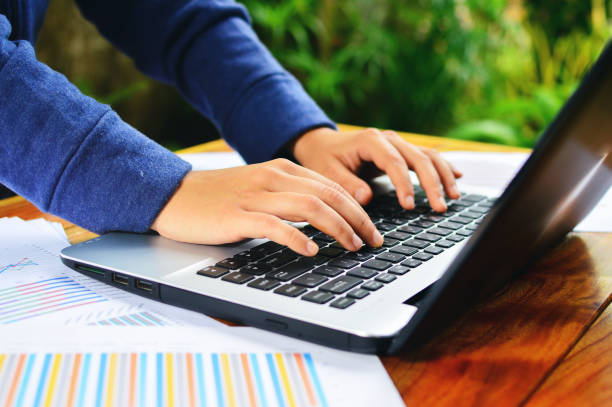istock Close up of people hand using smartphone and laptop on wooden table in technology and business concept 1327770992