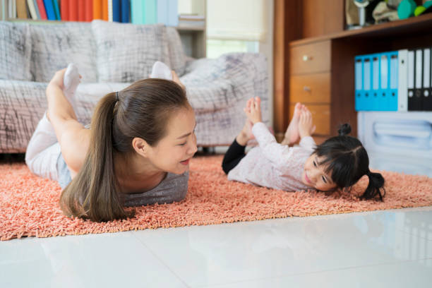 istock Asian mom practice Cobra yoga pose, work out at home with a adorable 1327777959