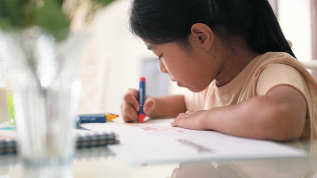 Asian girl drawing with crayon