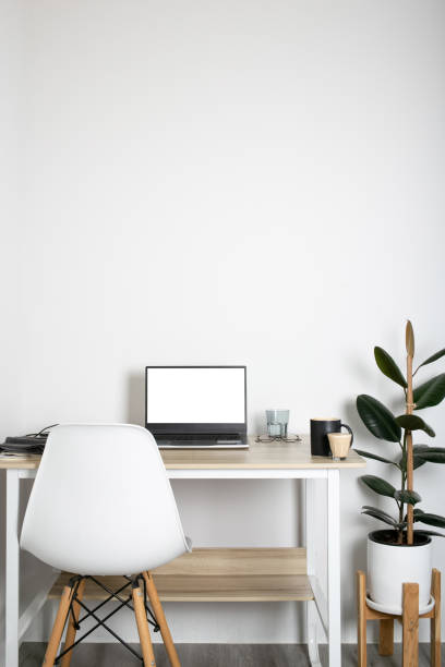 istock Empty on people. white bedroom with desk office space interior design With Mockup laptop supplies white screen tables and chairs and white walls. vertical 1327780828