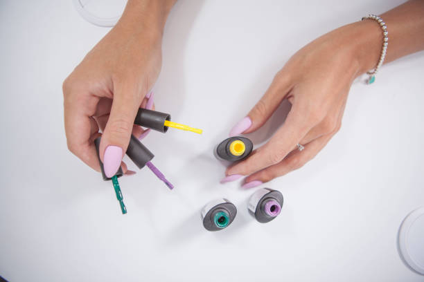 istock Manicurist holding colorful nail polish bottles 1327780876