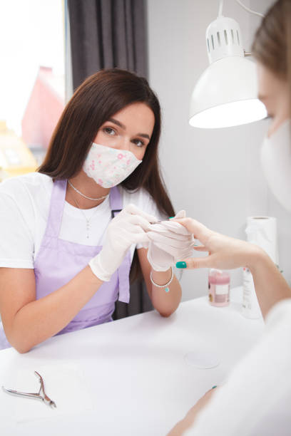 istock Manicurist working wearing face mask 1327780931
