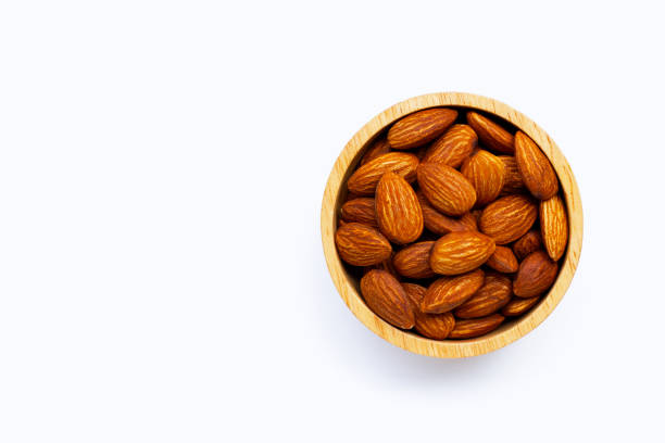 istock Almonds in wooden bowl on white background. 1327782937