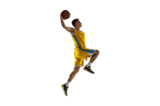 Side view. Young man, basketball player with a ball training isolated on white studio background. Advertising concept. Sportive Caucasian athlete playing basketball. Motion, activity, movement concepts.