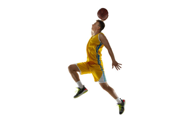 白いスタジオの背景に隔離されたボールを持つバスケットボール選手の完全な長さの肖像画。広告のコンセプト。ボールでジャンプする白人アスリートにフィット。 - isolated on white full length lifestyles yellow ストックフォトと画像