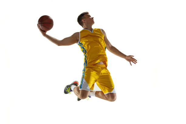 istock In action. One young man, basketball player with a ball training isolated on white studio background. Advertising concept. Caucasian athlete jumping with ball. 1327784317
