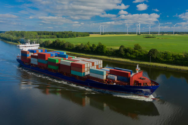istock Container ship on the Kiel Canal and windmill on the background. 1327784802