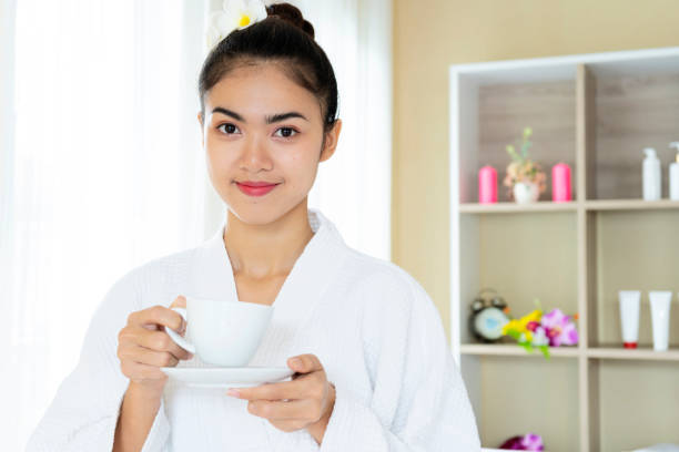 istock Woman in bath robe drinking tea in wellness spa 1327785794