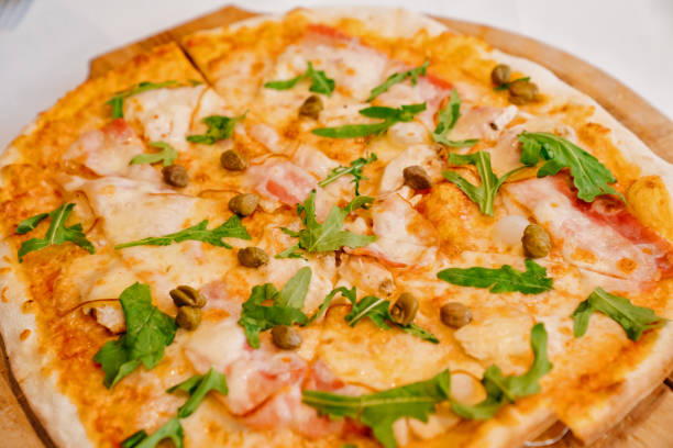 istock pizza with capers, arugula and bacon. traditional Italian cuisine. 1327786923