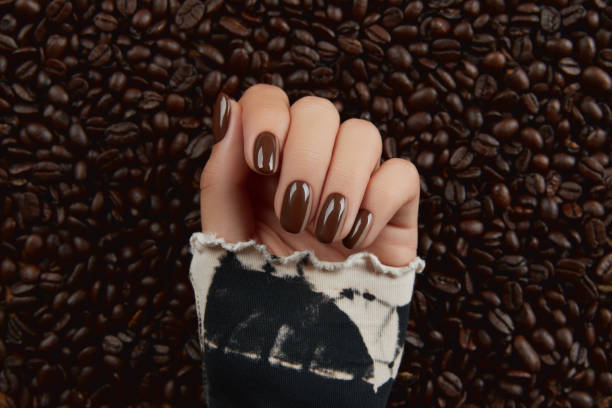 istock Beautiful groomed womans hand with brown nail design 1327788058