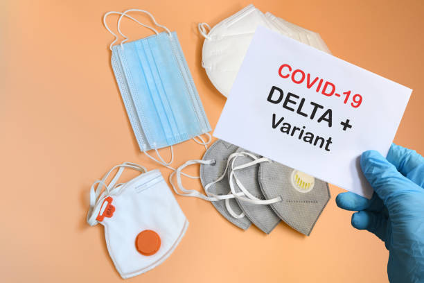 istock Doctor's hand in blue glove with white paper and text Covid-19 Delta + Variant with various protection masks on background. COVID-19 delta variant strain protection concept. 1327788591
