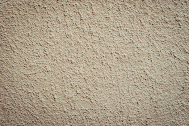 textura da parede de concreto de cor bronzeada marrom. stucco wall de perto. - color image solid brown bumpy - fotografias e filmes do acervo