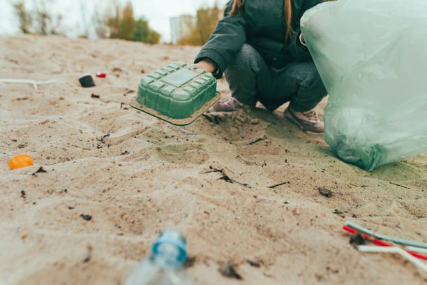 istock Kid picking up plastic garbage on the sand beach 1327793112