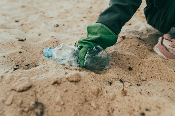 istock Kid picking up plastic garbage on the sand beach 1327793249