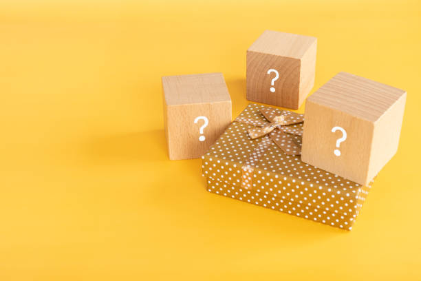 Selection of gift boxes; Wooden blocks with a question mark and a present box.