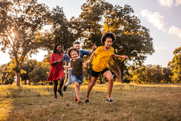 istock Parents playing and chasing with their daughters in park 1327793756