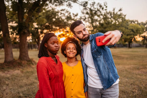 istock Multi-ethnic family making selfies in park 1327794468
