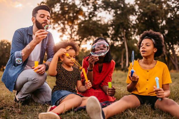 istock Multi-ethnic family blowing bubbles in park 1327794603