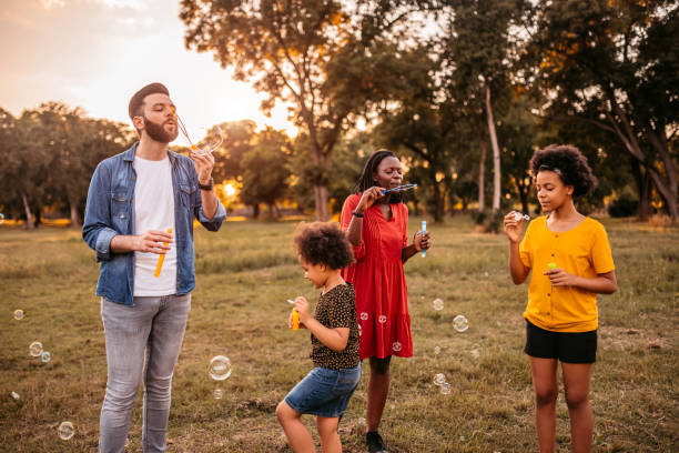istock Multi-ethnic family blowing bubbles in park 1327794647
