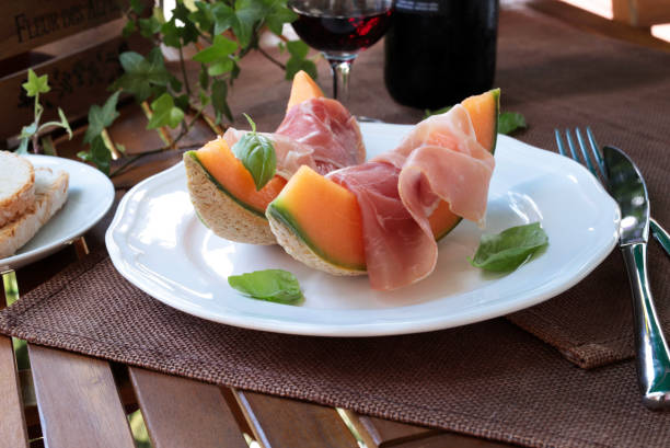 Melon with raw ham. Italian appetizer. Slices of melon with raw ham and Tuscan bread. Summer dish. Close-up. parma ham stock pictures, royalty-free photos & images