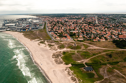Aerial image of Skagen and Vippefyr: Skagen is the very tip of Denmark where the waves of the two seas Kattegat and Skagerak meet. The old lighthouse, Vippefyret, is a historic landmark and was used for navigation from year 1627. This is a famous tourist attraction and national landmark. Image shot with drone.