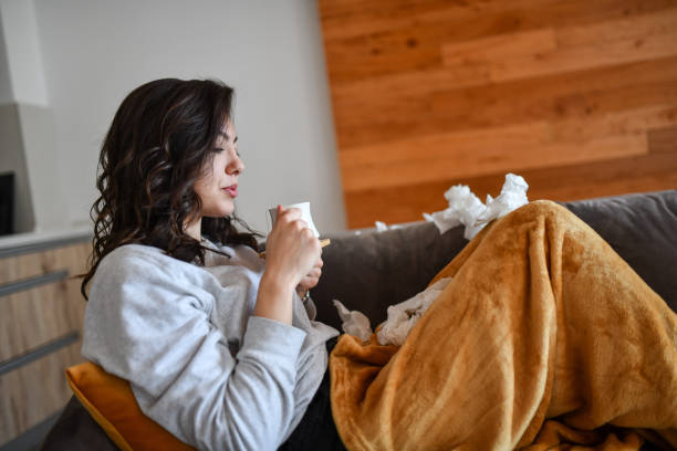 istock Female Drinking Tea While Struggling With COVID-19 Symptoms At Home 1327809366
